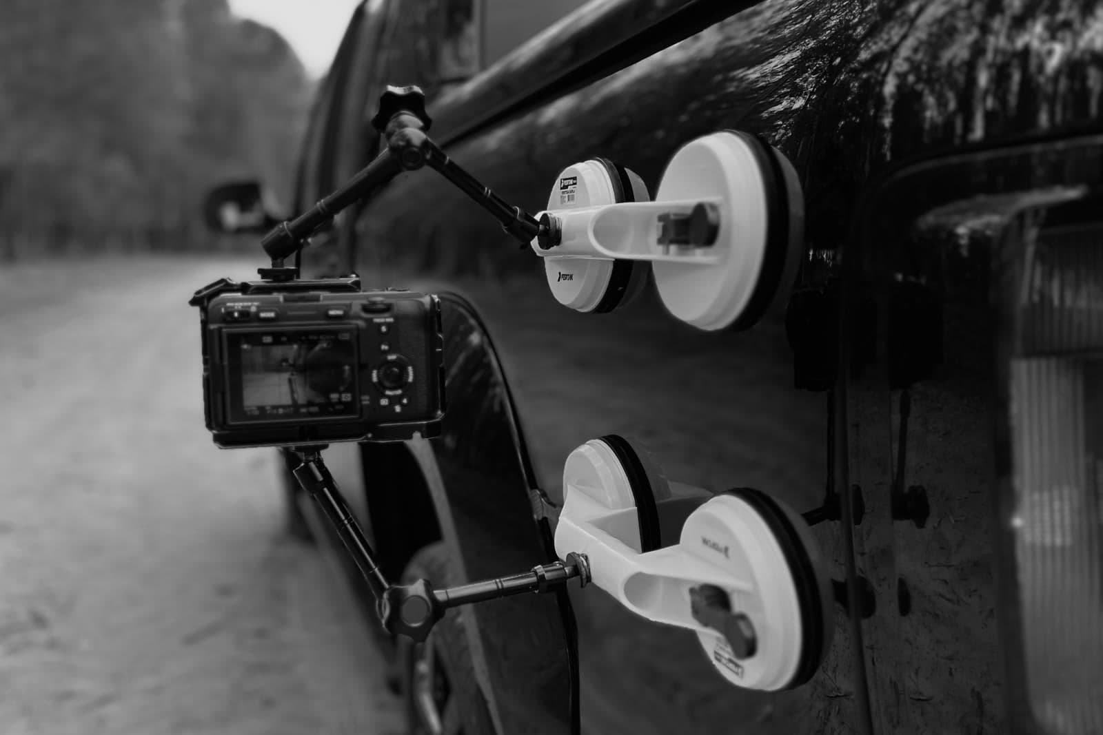 Camera mounted with suction cups on the side of a pickup truck, behind the scenes of a shoot