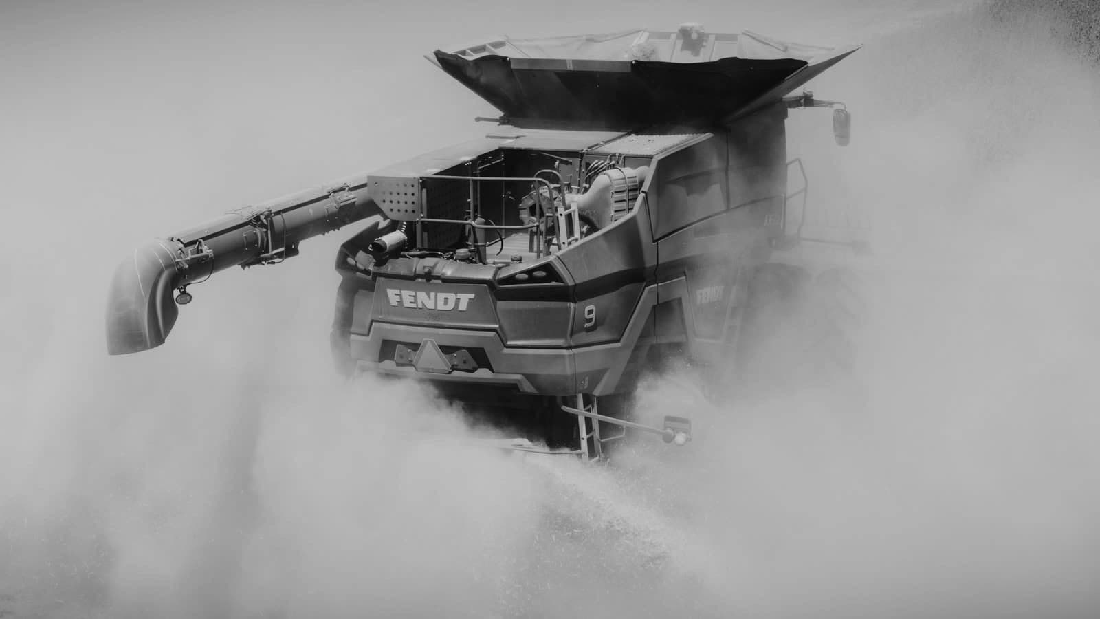 Combine harvester at work, raising dust in the field